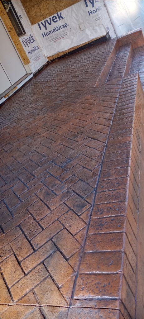 A beautifully crafted brick-patterned concrete patio with a step edge, part of Project Gallery.