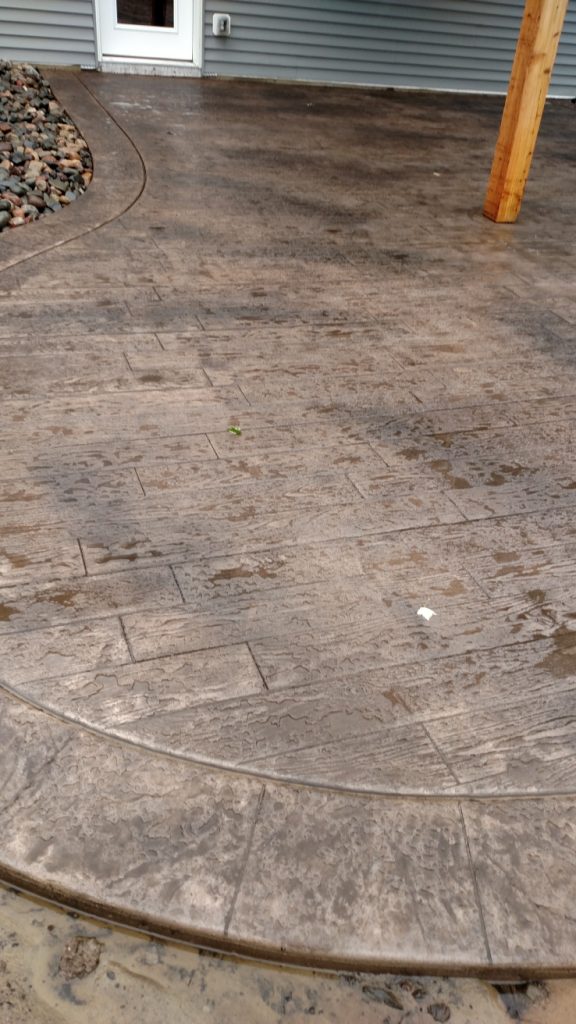 Stamped concrete patio with textured surface and decorative patterns for outdoor space enhancement.