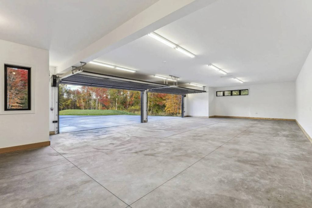 Spacious empty garage with open doors and concrete floor