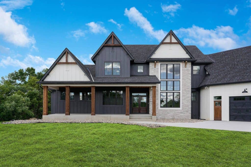 Modern farmhouse with large windows and green lawn