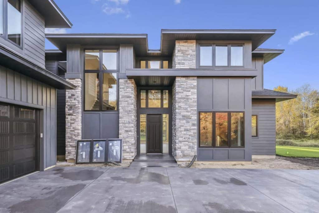 Modern two-story home with stone facade and large windows