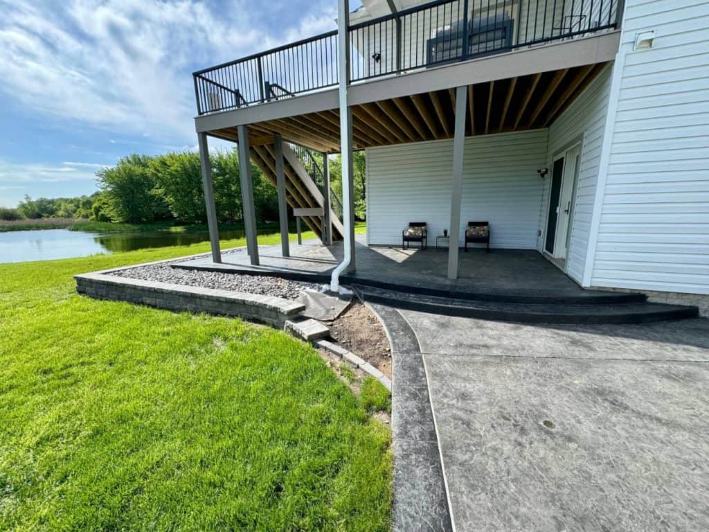 Backyard patio and elevated deck overlooking pond