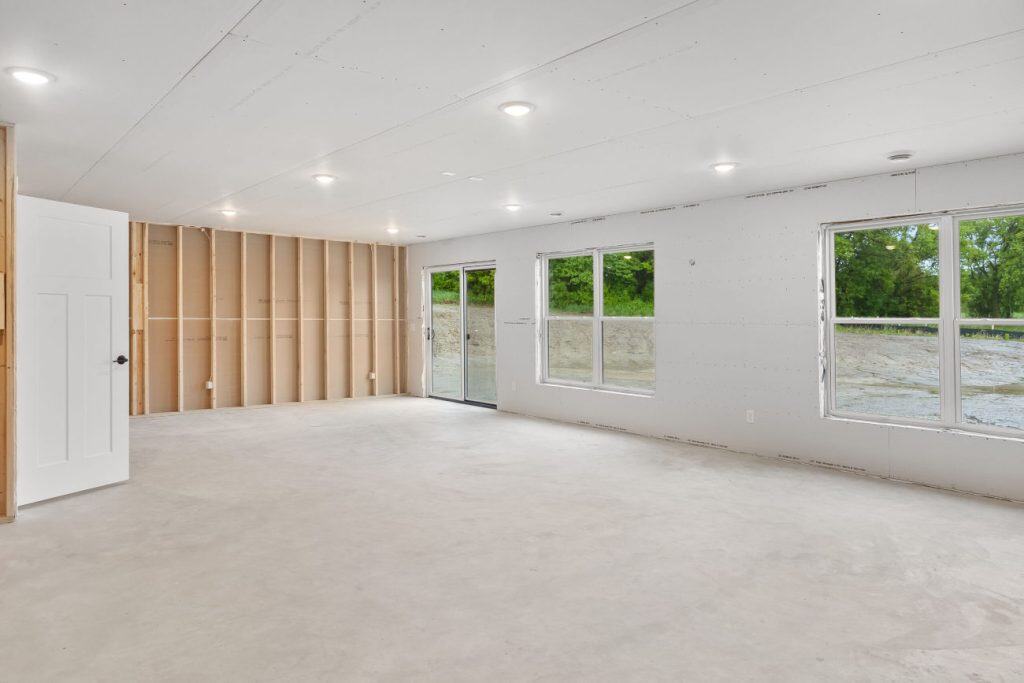 Unfinished basement with windows, drywall, and recessed lighting