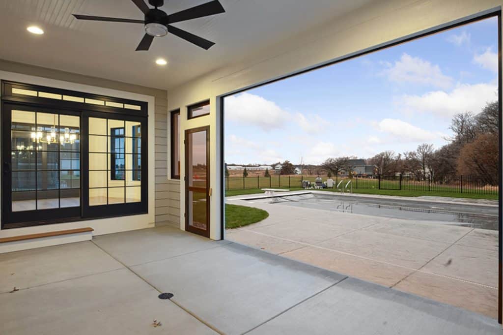 Covered patio with ceiling fan overlooking backyard pool