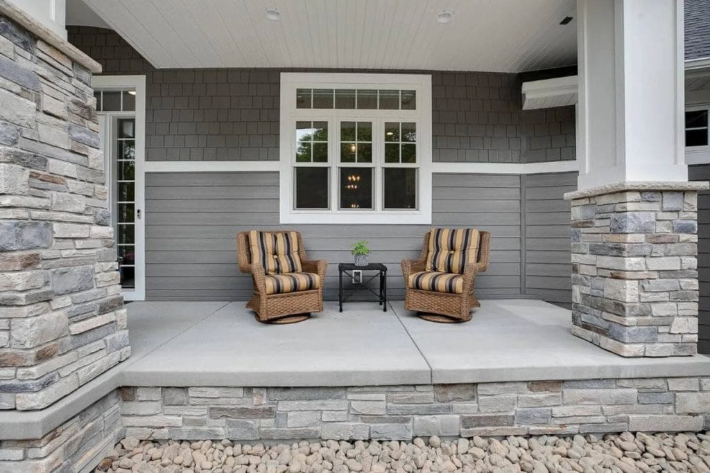 Covered front porch with wicker chairs and table